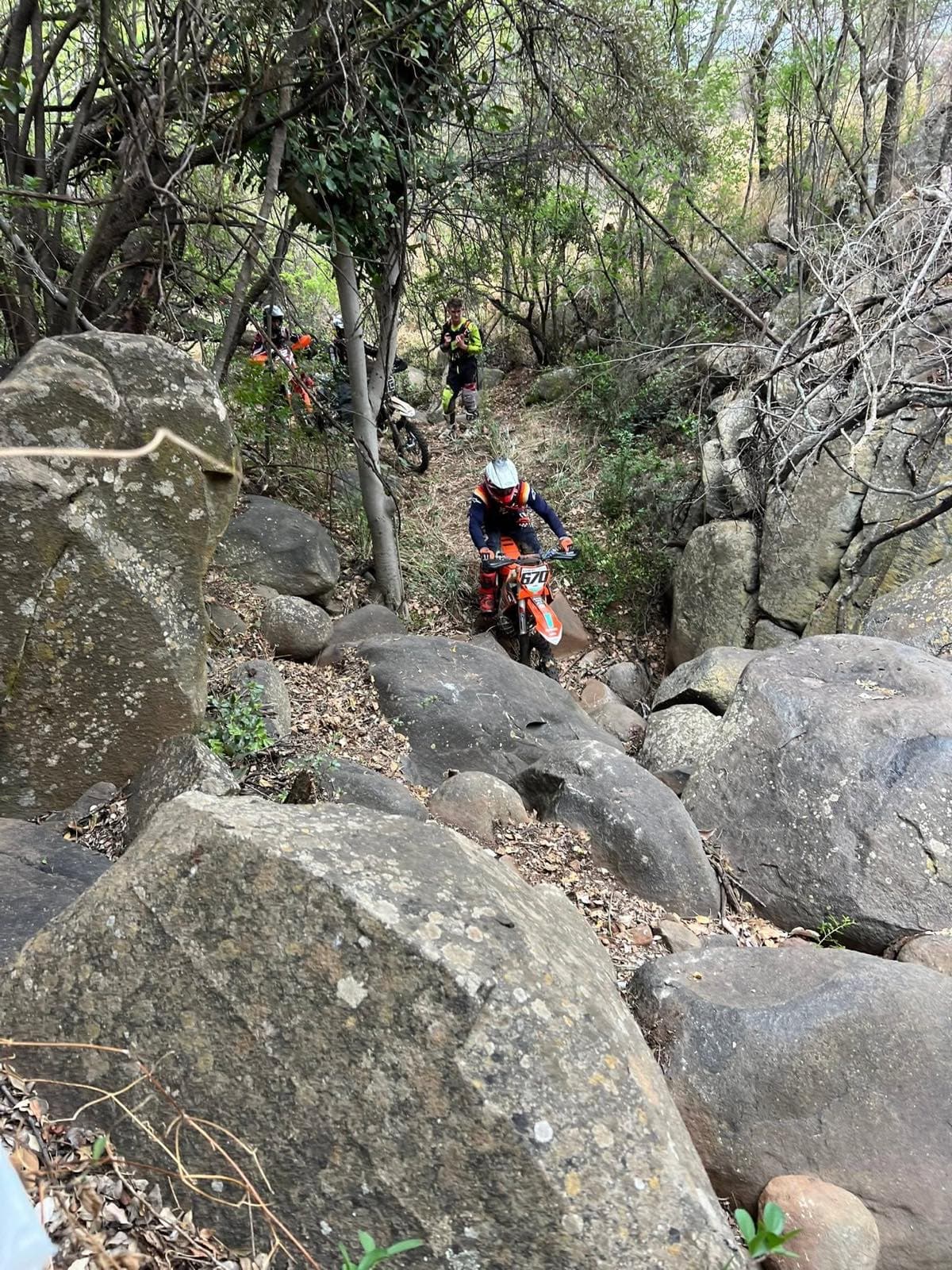 Riders working through a boulder-choked gully
