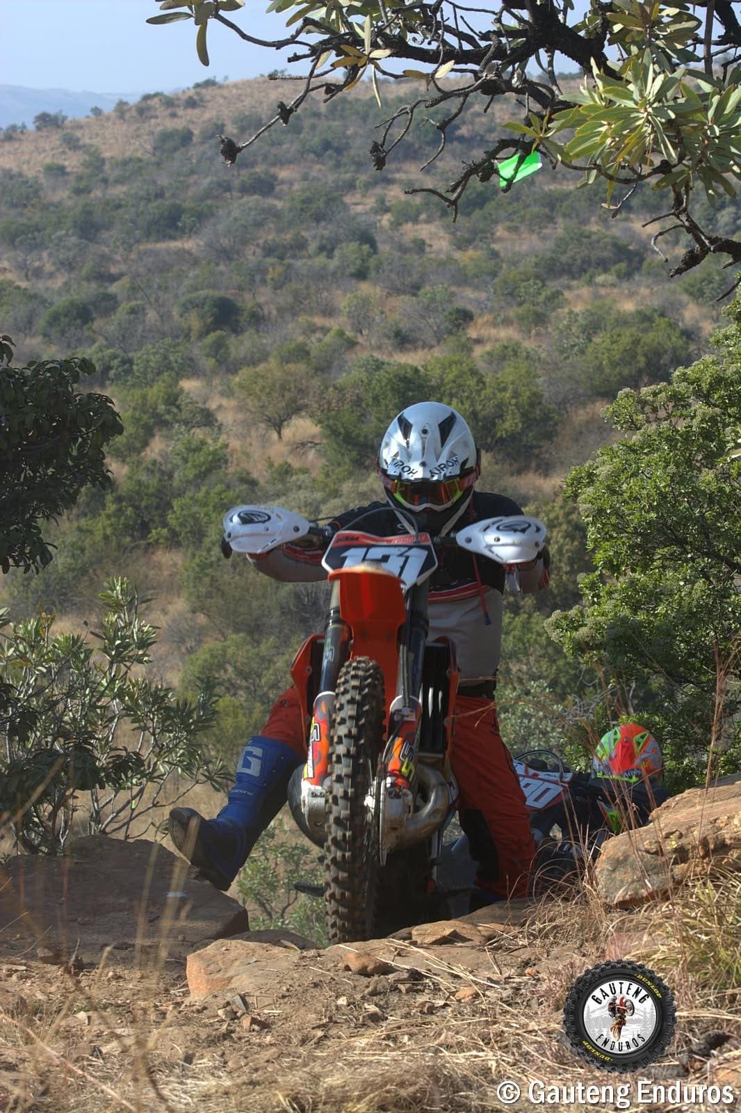 Rider dropping off a rock ledge on a KTM